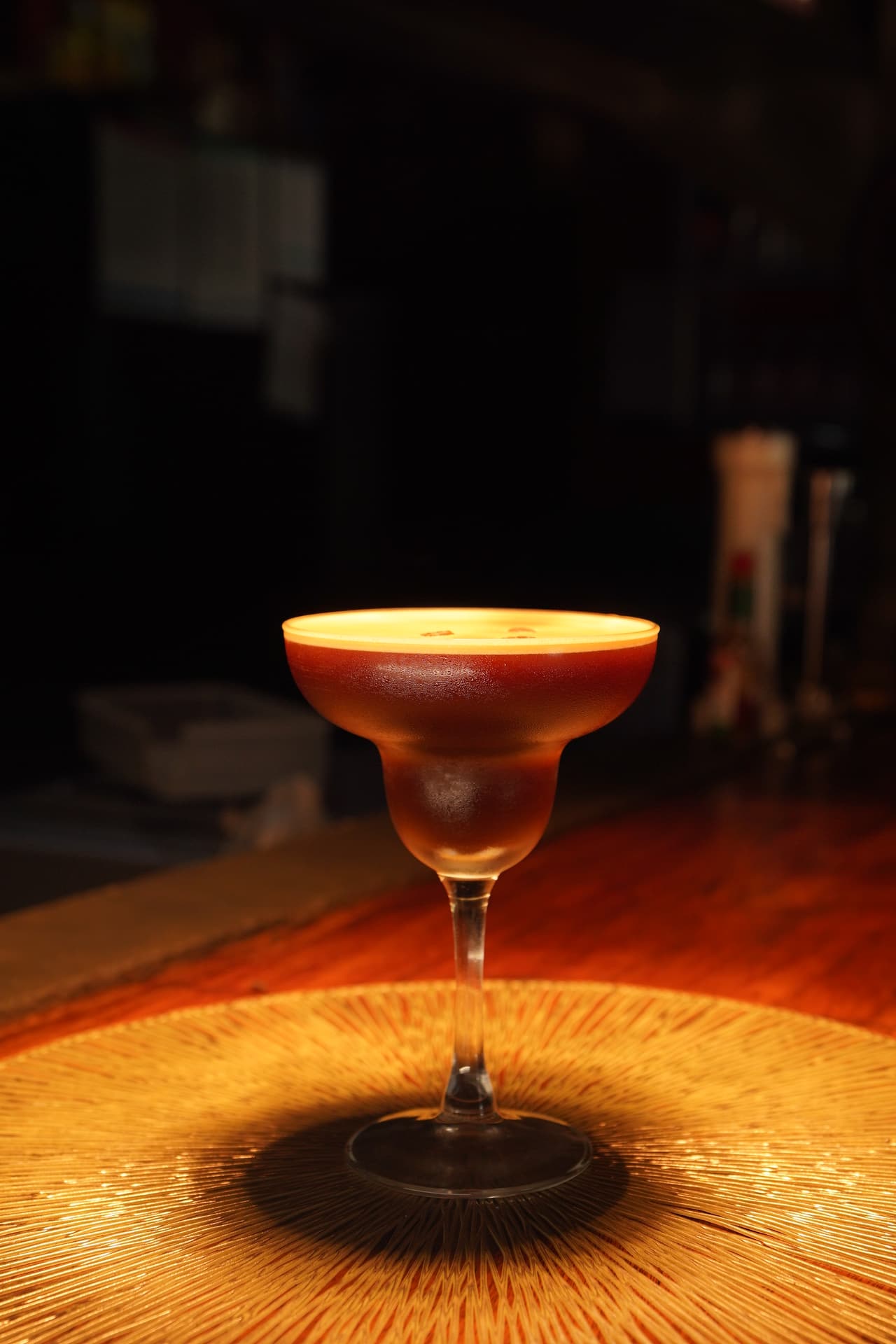 An espresso martini at AK Ristoro, Ella — a crema-topped glass on a woven mat