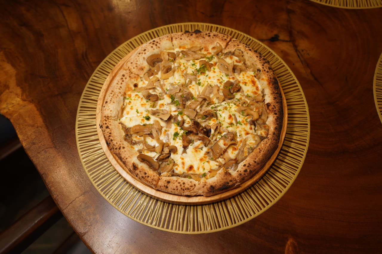 Funghi bianco pizza at AK Ristoro, Ella — mushrooms and mozzarella on a white base, on a woven placemat