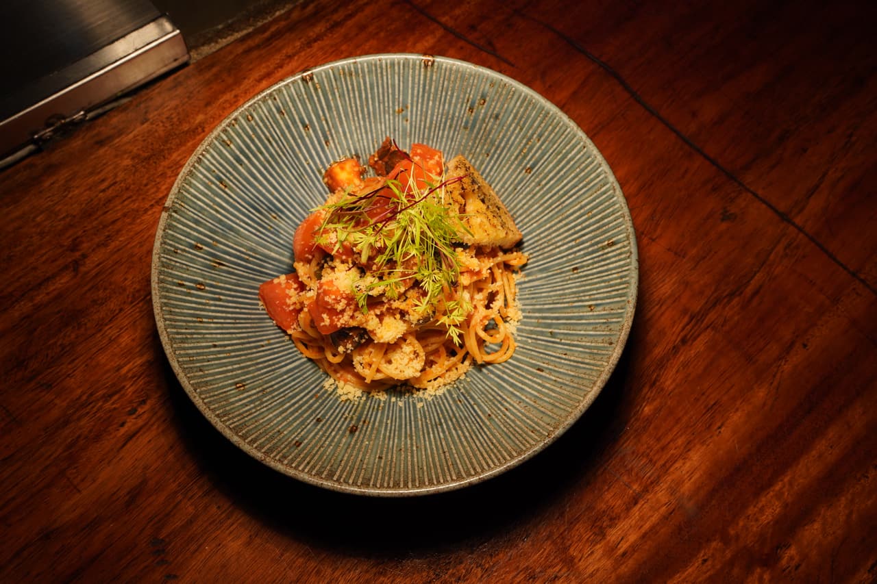 A tomato seafood pasta at AK Ristoro, Ella — shrimp, Parmesan and herbs on a ribbed celadon plate