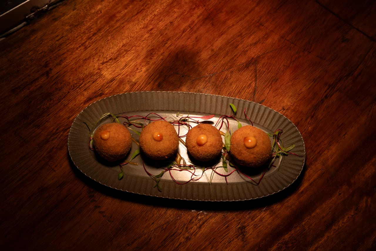 Sri Lankan croquettes at AK Ristoro, Ella — four golden crumbed croquettes on a dark oval plate